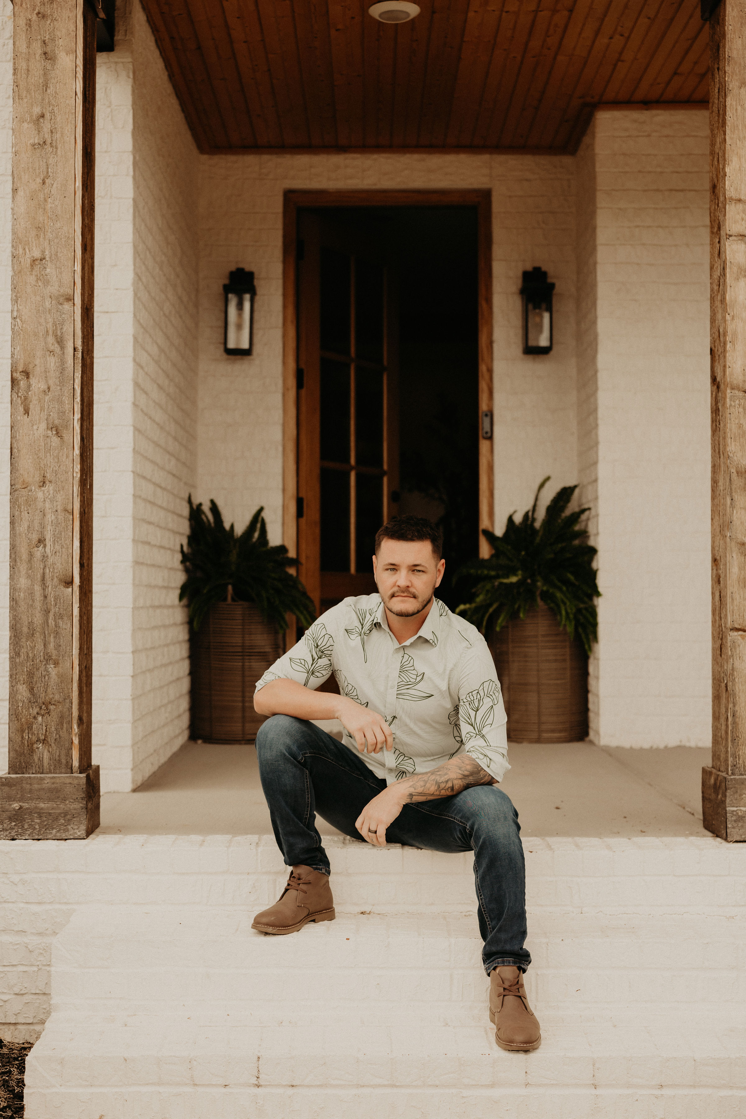 Michael Easton seated on the front steps of a home
